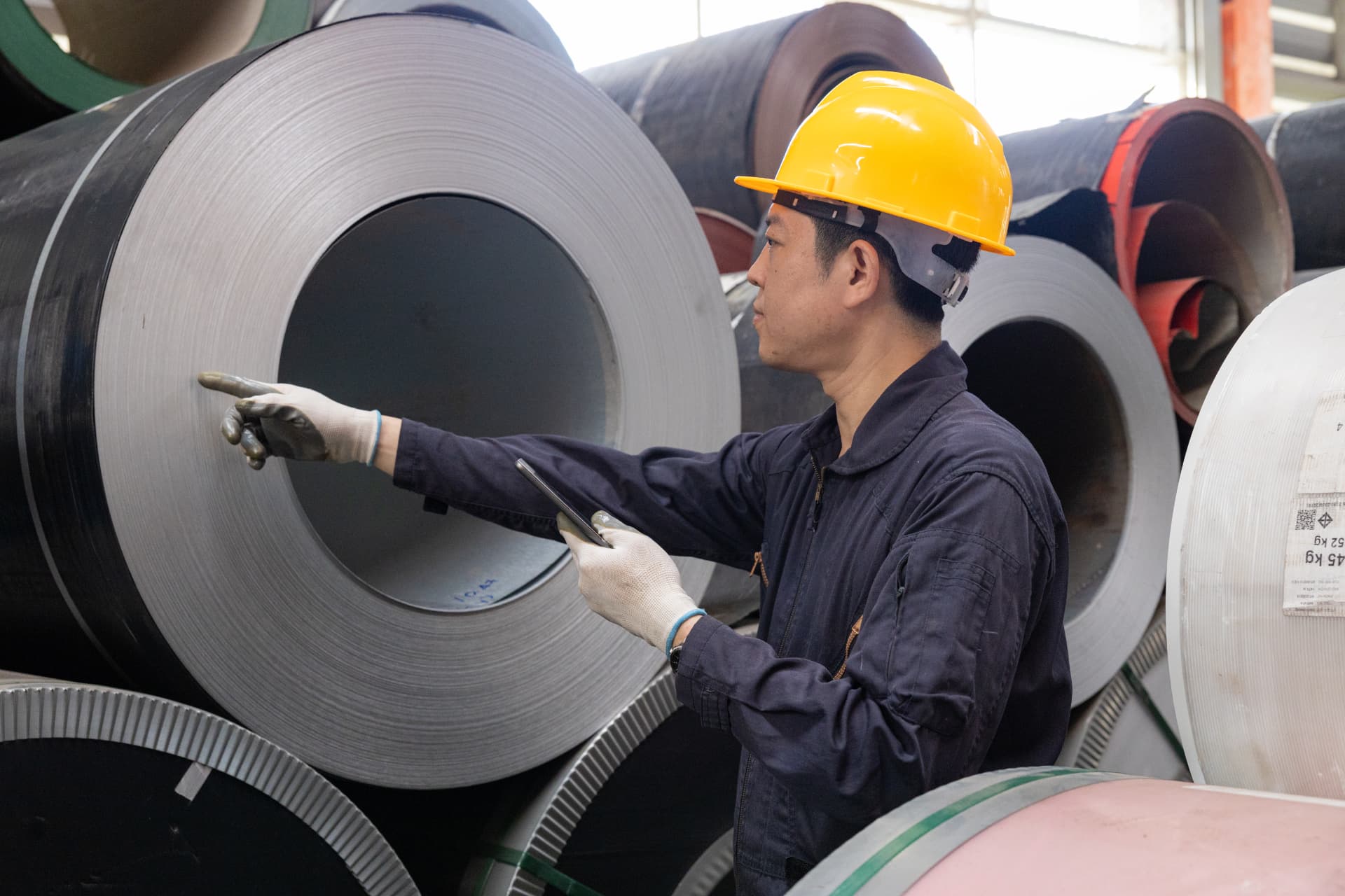 Worker inspecting steel coils